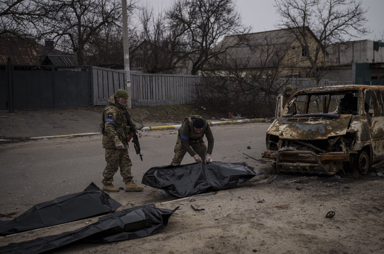 Ukrainian soldiers recover the remains of four killed civilians from inside a charred vehicle in Bucha, outskirts of Kyiv, Ukraine, Tuesday, April 5, 2022. (AP Photo)