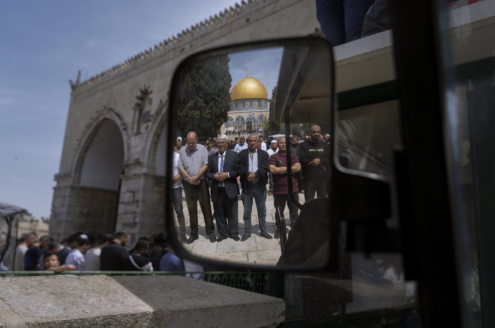 Muslim men are reflected in a mirror as they offer Friday prayers next to the Dome of the Rock Mosque in the Al-Aqsa Mosque complex in occupied East Jerusalem, Palestine, April 1, 2022. (AP Photo)