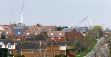 Wind turbines are seen behind houses in Burton Latimer, Britain, March 30, 2022. (Reuters Photo)