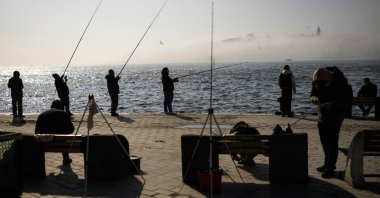 Fishermen cast their lines into the Bosporus at a promenade during a foggy morning in Karaköy, Istanbul, Turkey, April 6, 2022. (AP Photo)