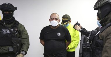 In this photo released by the Colombia Police Press Office, one of the country's most wanted drug traffickers, Dairo Antonio Usuga, alias "Otoniel," is handcuffed upon his arrival to Bogota, Colombia, Oct. 23, 2021. (AP Photo)