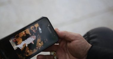 Father Ebu Izzet Hibbiye shows photos on his phone to an Anadolu Agency correspondent, al-Bab, Syria, March 7, 2022 (AA Photo)