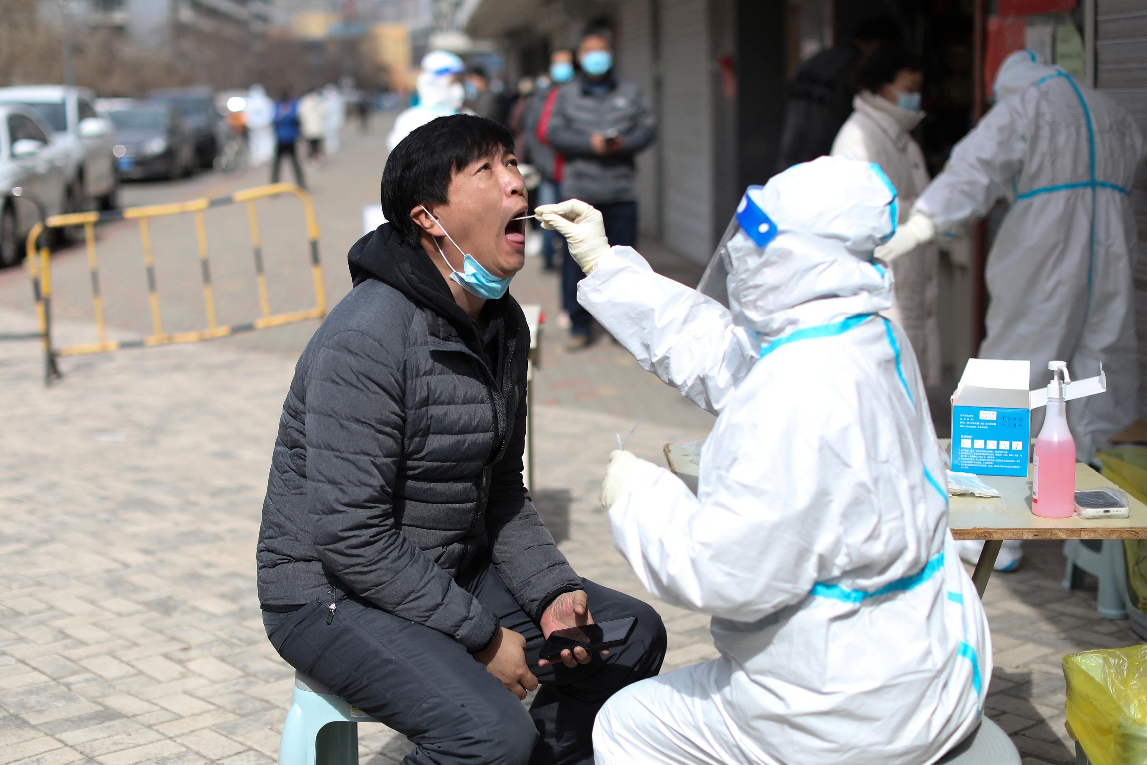 A resident undergoes a nucleic acid test for COVID-19 in Shenyang in China&#039;s northeastern Liaoning province, April 7, 2022. (Photo by AFP)