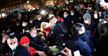 French officers face migrants, officials and NGO volunteers at a makeshift tent camp on Republique square in Paris, France, Nov. 23, 2020. (AFP Photo)