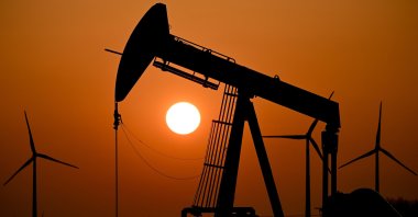 A pump jack conveys crude oil as the sun sets behind an oil field near the German-Durch border in Emlichheim, Germany, March 22, 2022. (EPA Photo)