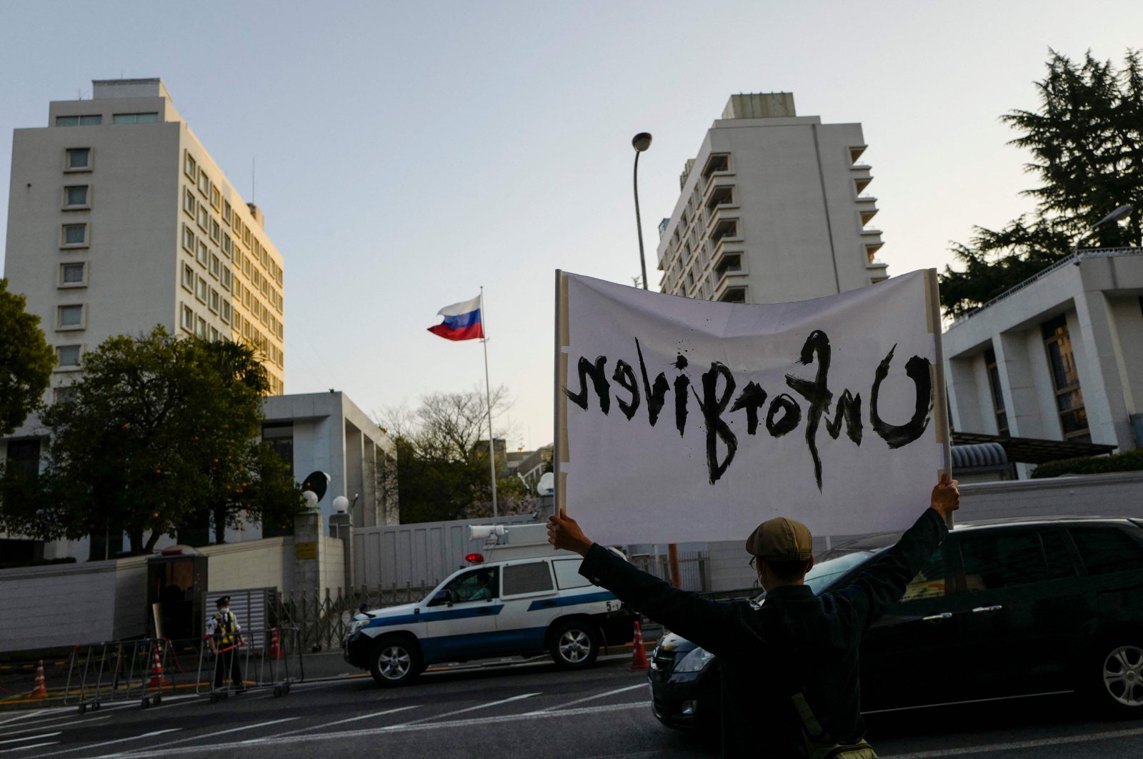 A man holds a sign in front of the Russian Embassy in Tokyo, Japan, April 8, 2022. (AFP Photo)