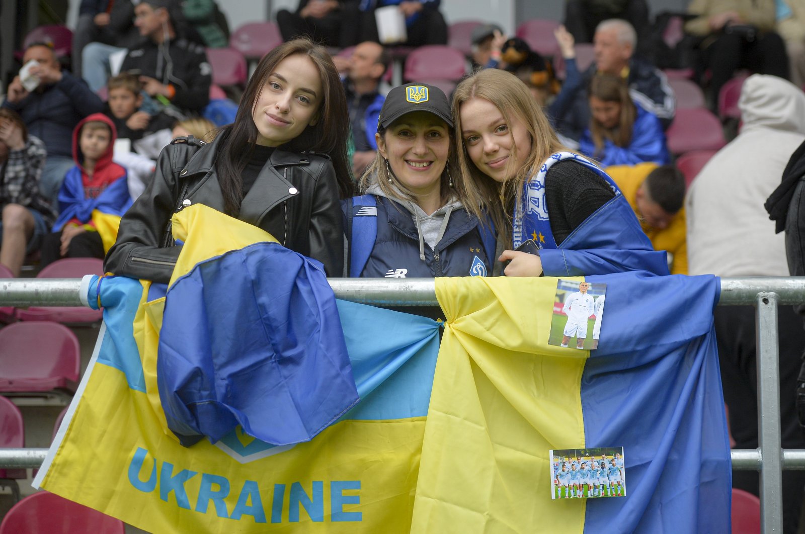 Ukrainian supporters pose next to the Ukrainian flag during the European Youth League round of 16 soccer match between Dynamo Kyiv U19 and Sporting CP U19, at the Giulesti stadium in Bucharest, Romania, April 7, 2022. (AP Photo)