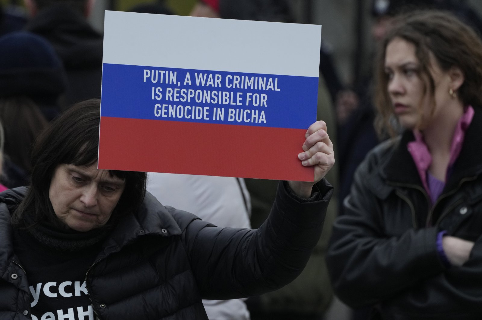 A woman holds a banner in the colors of the Russian flag during an anti-war rally in front of the Russian Embassy in Warsaw, Poland, April 6, 2022. (AP Photo)