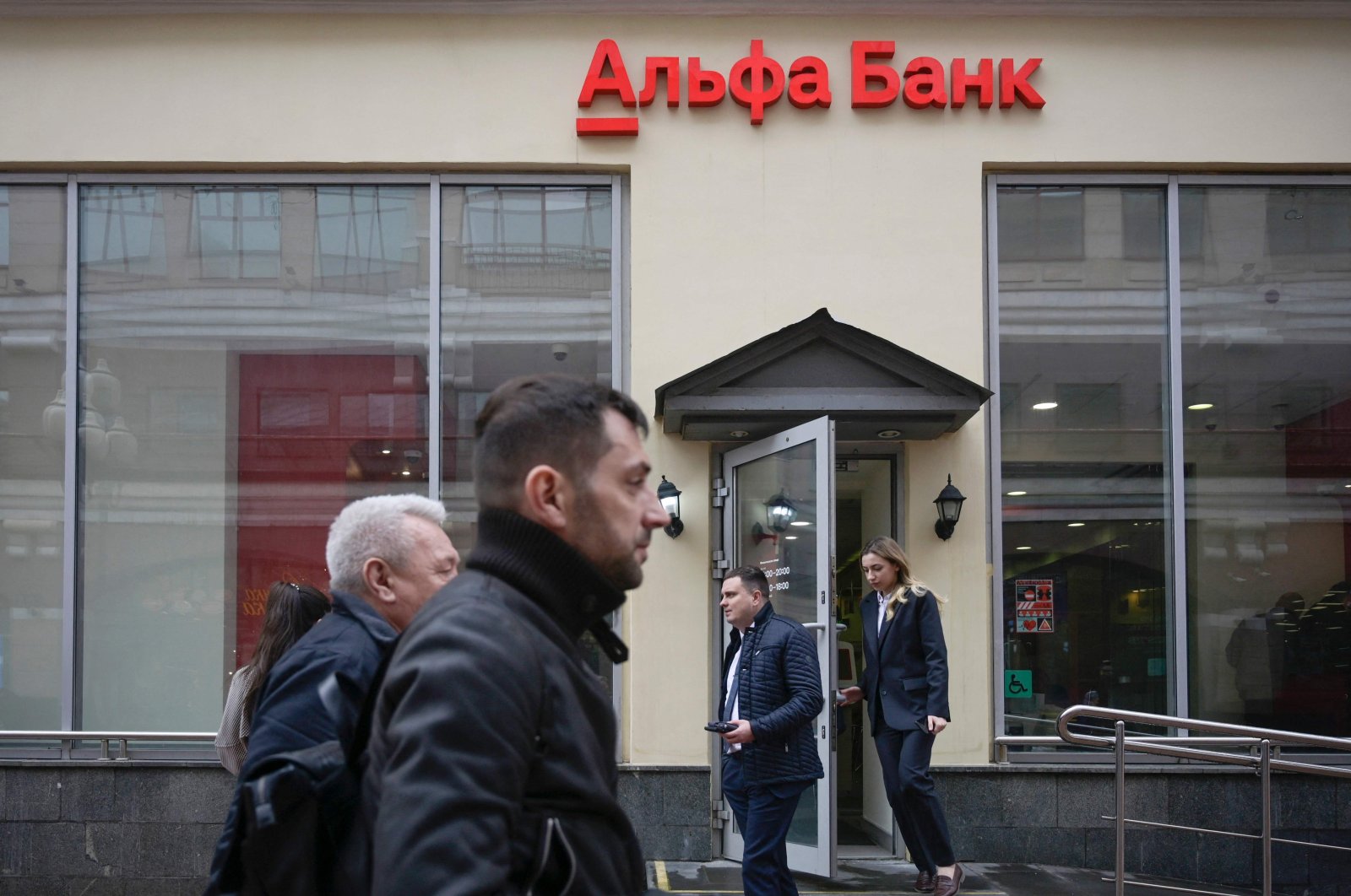 Pedestrians walk past the branch of Alfa Bank, Russia&#039;s largest private bank, in Moscow, April 7, 2022. (AFP Photo)