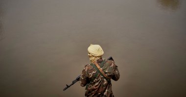 Malian soldier patrols the riverbank in Konna as the Malian prime minister and his delegation visit the town in central Mali to attend the inauguration of the new river port, which was destroyed by bombing during the war in 2013. (AFP PHoto)