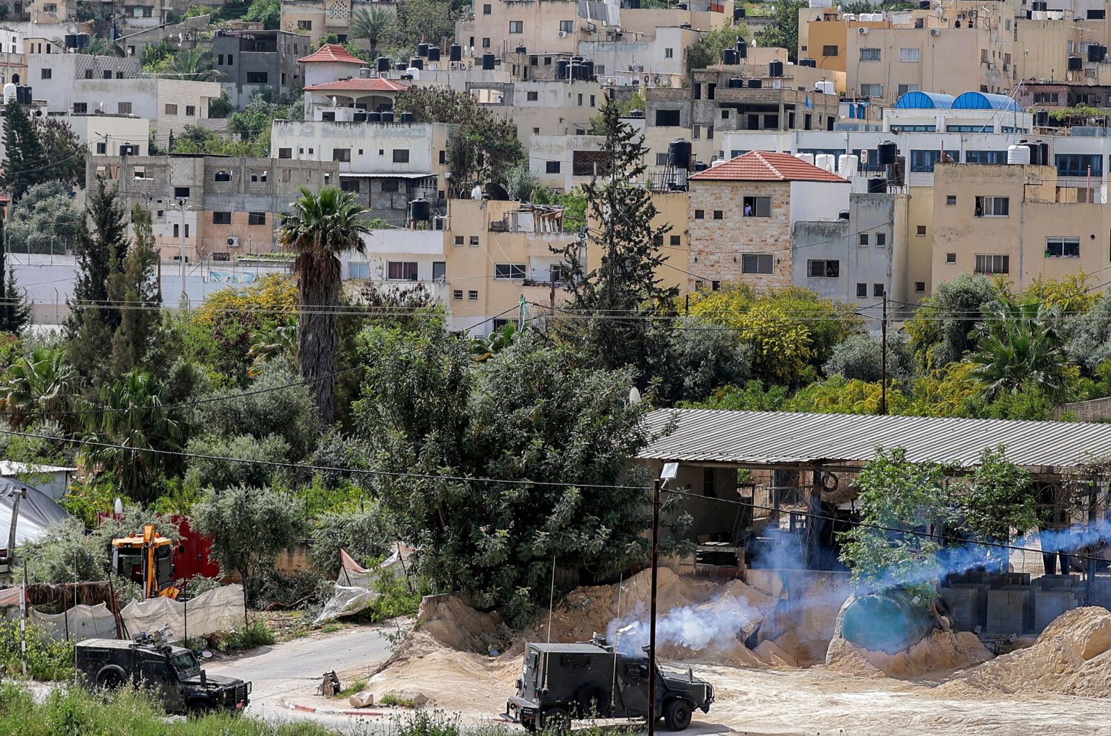 Tear gas canisters are fired from an Israeli military vehicle near the Palestinian refugee camp of Jenin, killing a Palestinian and wounding others, after Israel vowed there will "not be limits" to curb surging violence, in the occupied West Bank, Palestine, April 9, 2022. (AFP Photo)