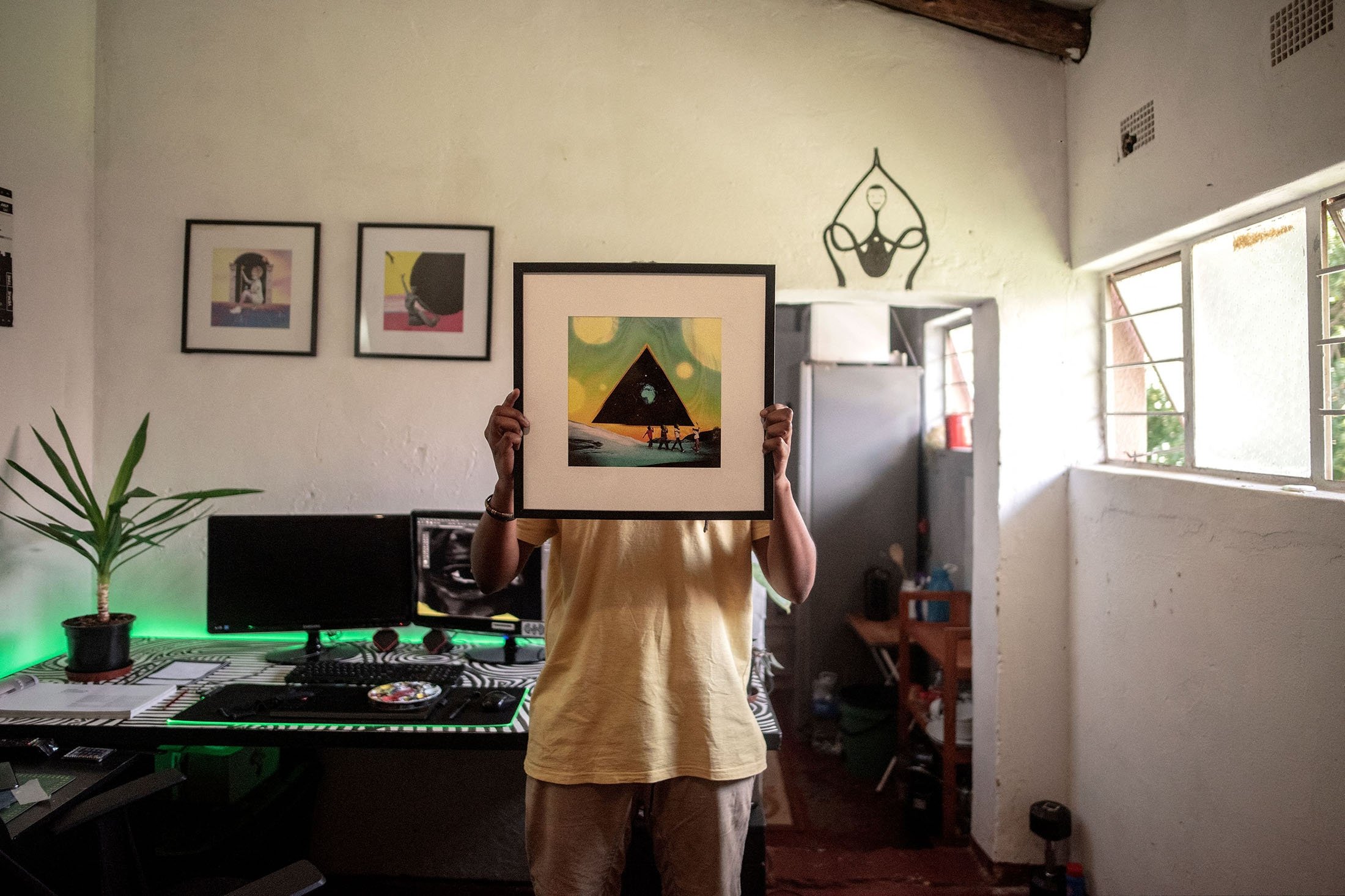 Seniman visual vonMash berpose untuk potret di studionya saat ia menutupi wajahnya dengan karya seni yang dibuat oleh DJ Black Coffee yang terkenal di dunia, di Springs, Afrika Selatan, 7 Februari 2022. (AFP Photo)
