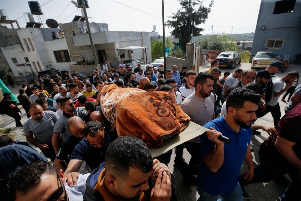 People carry the body of Palestinian woman Ghada Sabatin, who medics said was killed by Israeli forces, during her funeral in Husan in the Israeli-occupied West Bank, Palestine, April 10, 2022. (Reuters Photo)
