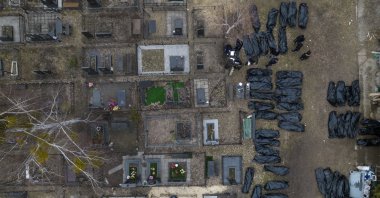Police officers work to identify civilians killed during the Russian occupation in Bucha, Ukraine, on the outskirts of Kyiv, before sending the bodies to the morgue, April 6, 2022. (AP Photo)