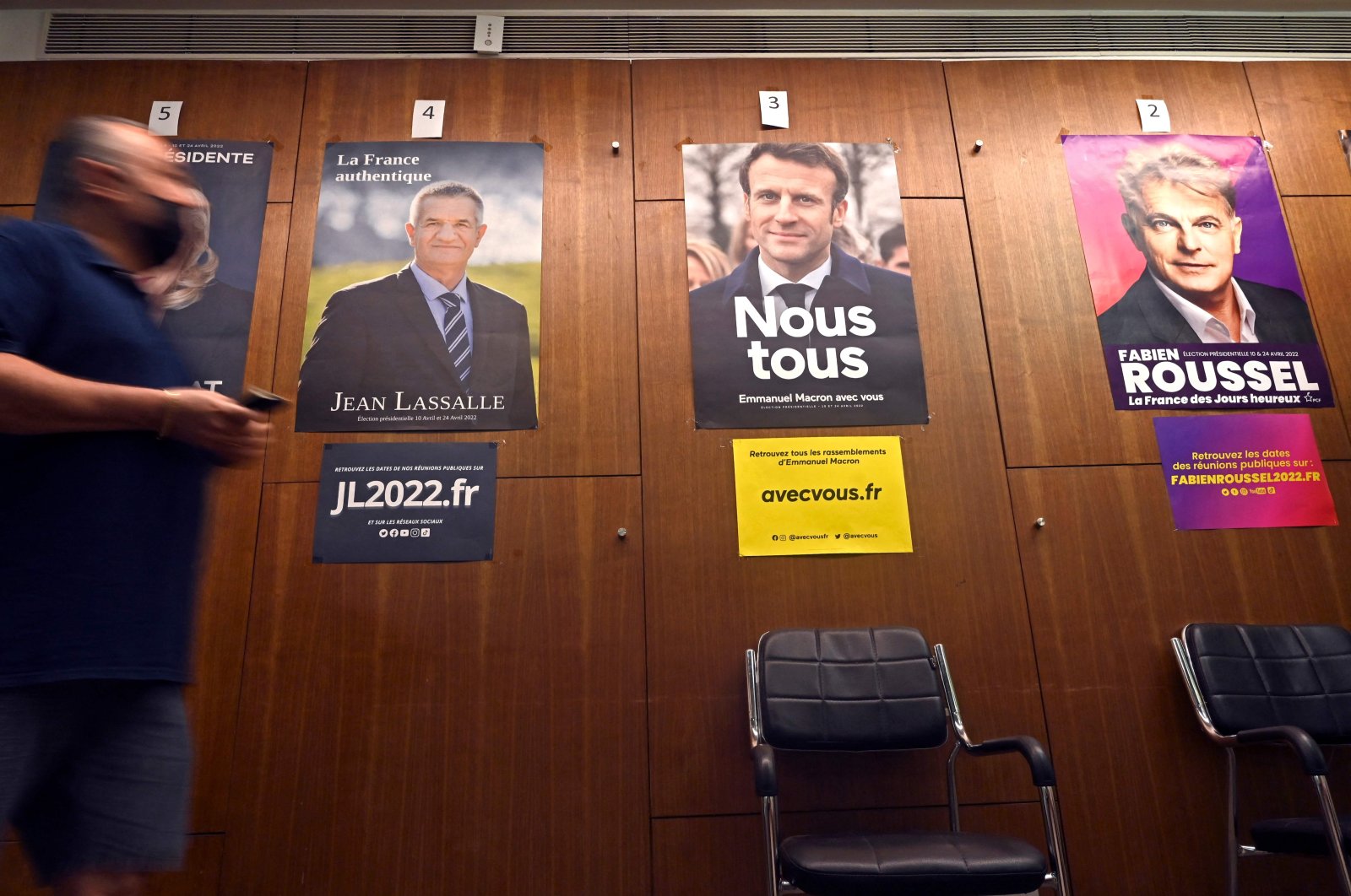 A French national living in India walks past the posters of French presidential candidates, as he arrives to cast his vote in the first round of the country&#039;s presidential elections at the Consulate of France in Mumbai on April 10, 2022. (AFP Photo)