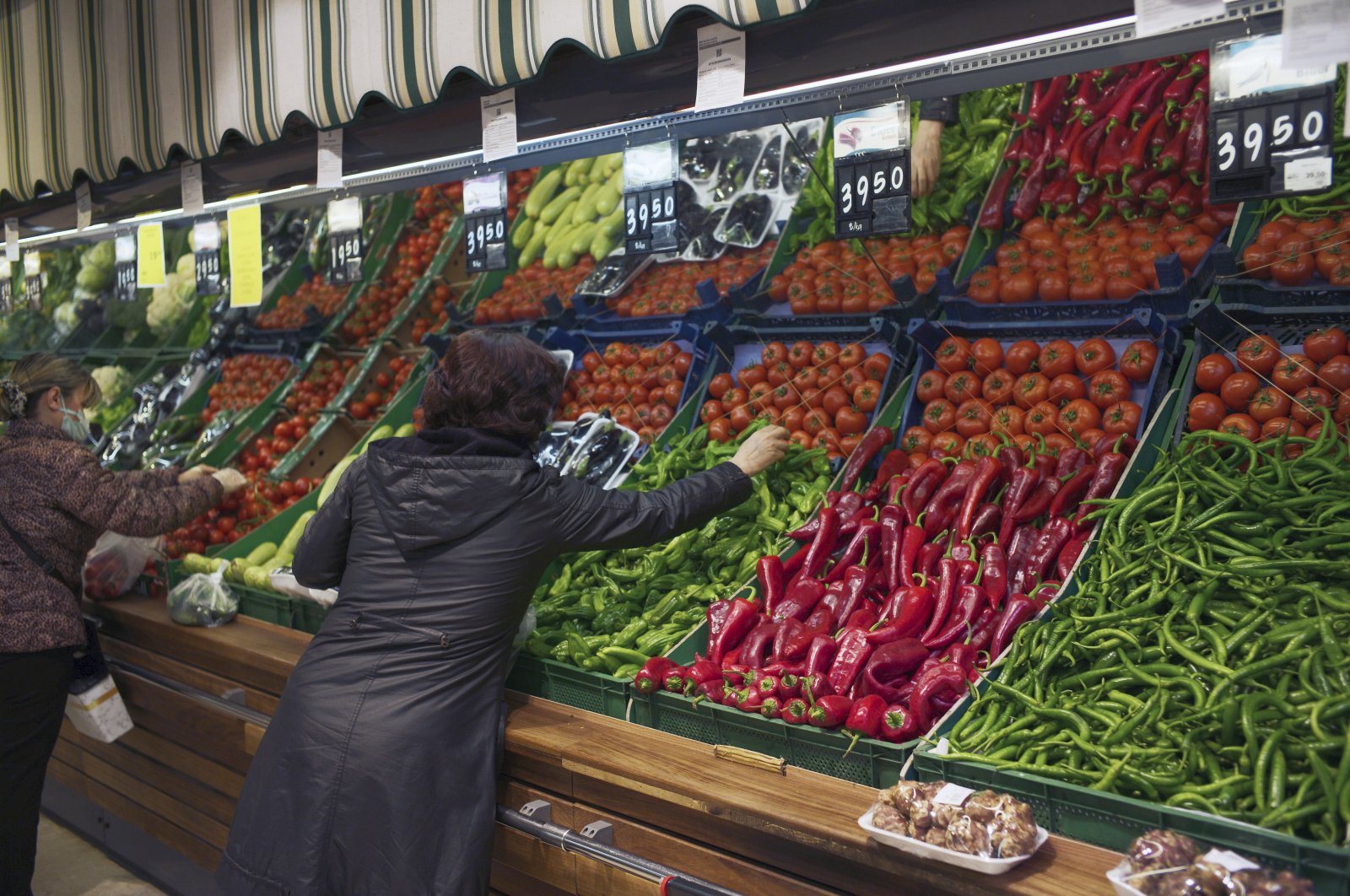Women buy vegetables at a food market, in Ankara, Turkey, April 8, 2022. (AP Photo)