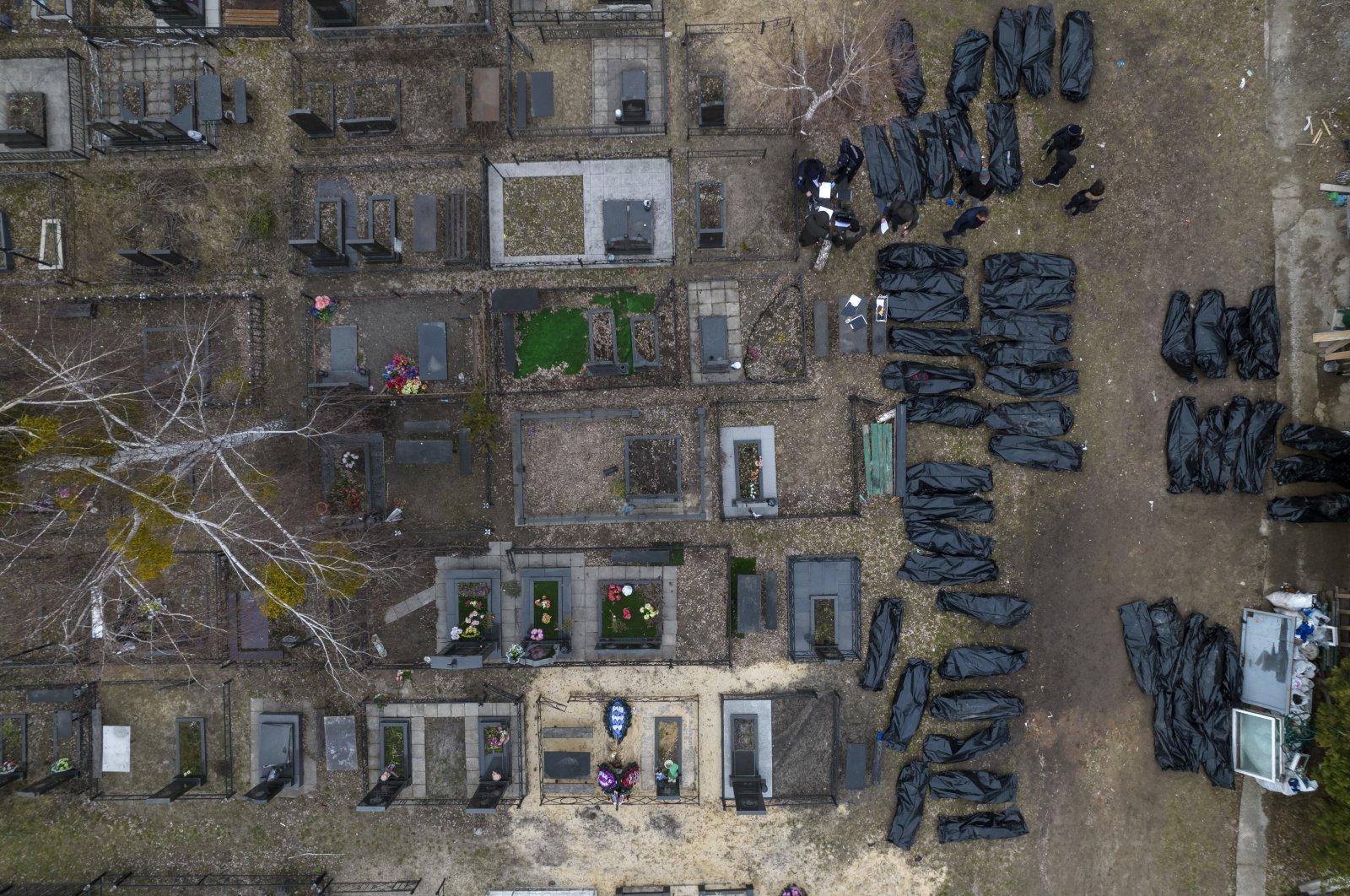 Police officers work to identify civilians killed during the Russian occupation in Bucha, Ukraine, on the outskirts of Kyiv, before sending the bodies to the morgue, April 6, 2022. (AP Photo)