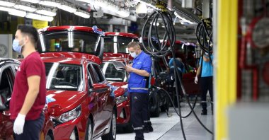 Workers are seen beside new i20 model cars at Hyundai Assan's Izmit factory in northwestern Kocaeli, Turkey, Aug. 28, 2020. (AA Photo)