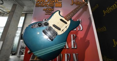 The blue 1969 Mustang Fender guitar used by rock icon Kurt Cobain in the 1991 Nirvana music video "Smells Like Teen Spirit" is displayed at the media preview of the "Music Icons" auction, at Julien's Auctions in Beverly Hills, California, on April 11, 2022. (AFP)