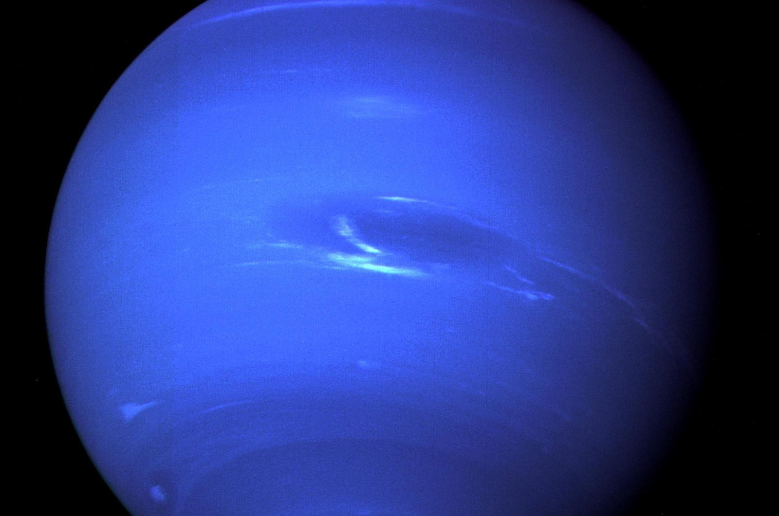 The &quot;Great Dark Spot,&quot; a storm in the atmosphere and the bright, light-blue smudge of clouds that accompanies the storm is seen on the planet Neptune, taken by the NASA spacecraft Voyager 2, Aug. 25, 1989. (NASA via Reuters)