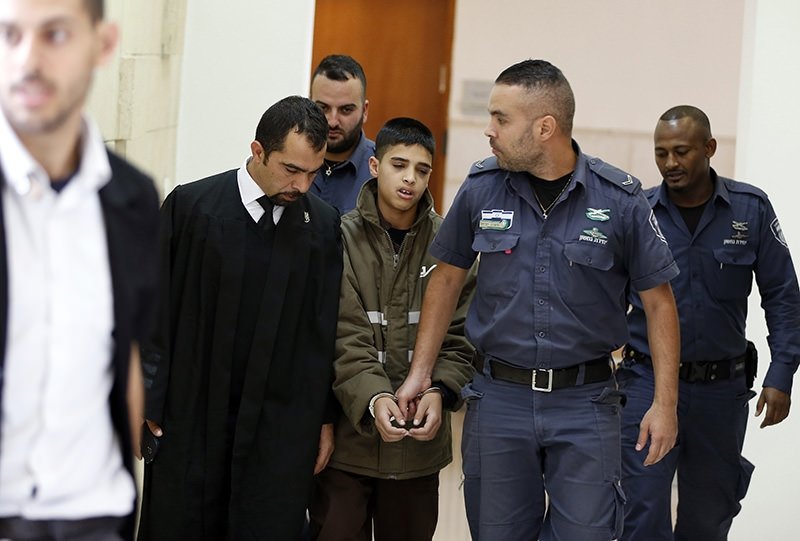Ahmed Manasra (C), a 13-year-old Palestinian accused of taking part in the stabbing of two Israelis, is escorted by Israeli security during a hearing at a Jerusalem court, Oct. 30, 2015. (AFP Photo)