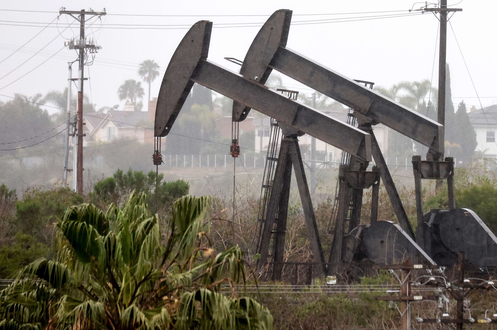 An oil pumpjack (R) operates as another (C) stands idle in Los Angeles, California, U.S., March 28, 2022. (AFP Photo)