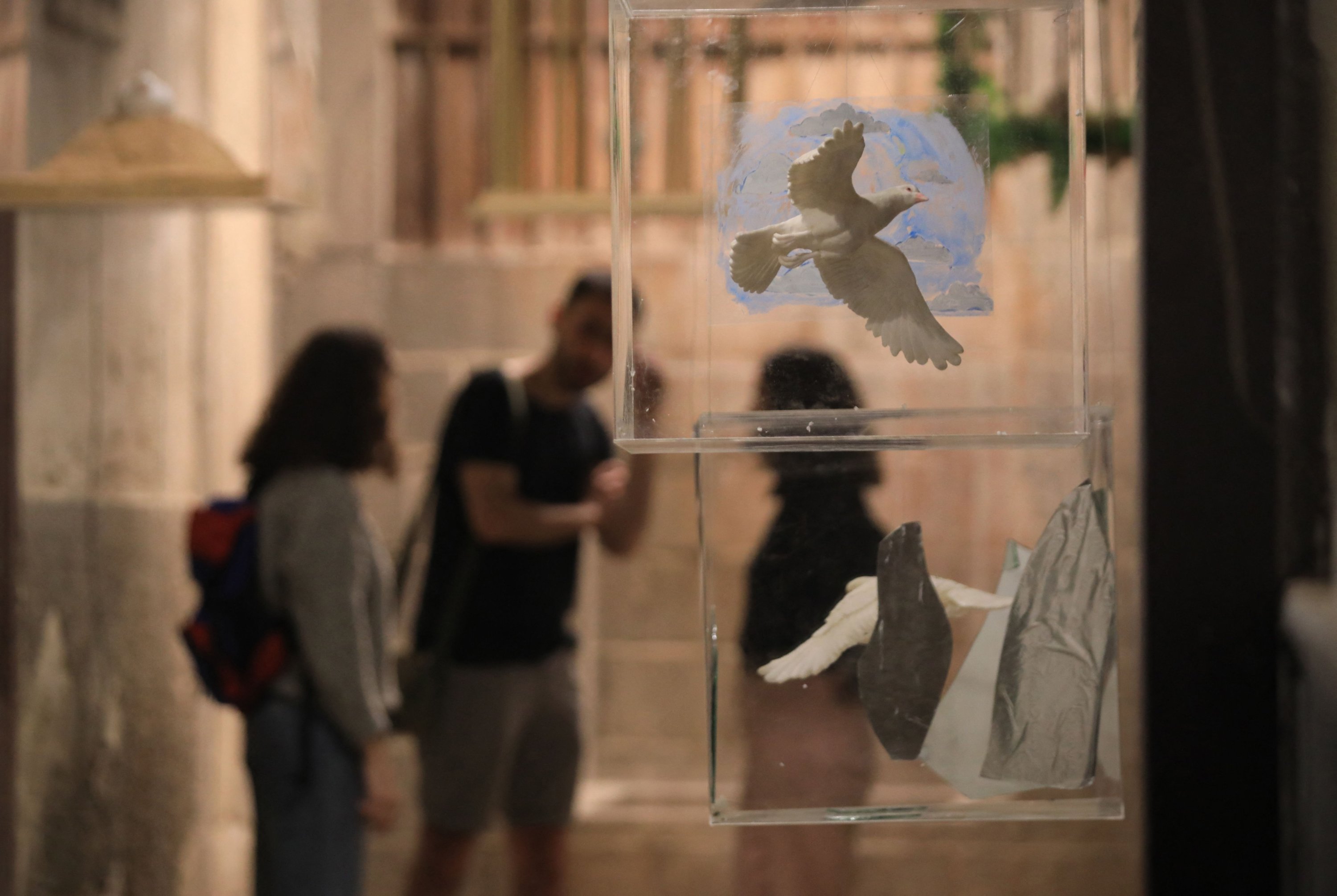 Pengunjung melihat instalasi seni menggunakan merpati keramik di galeri seni di Damaskus tua, sebagai bagian dari pameran berjudul 