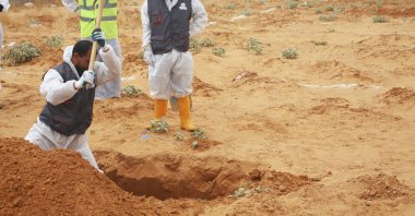 Libyan Ministry of Justice employees dig out at a site of a suspected mass grave in the town of Tarhuna, Libya, June 23, 2020. (AP)