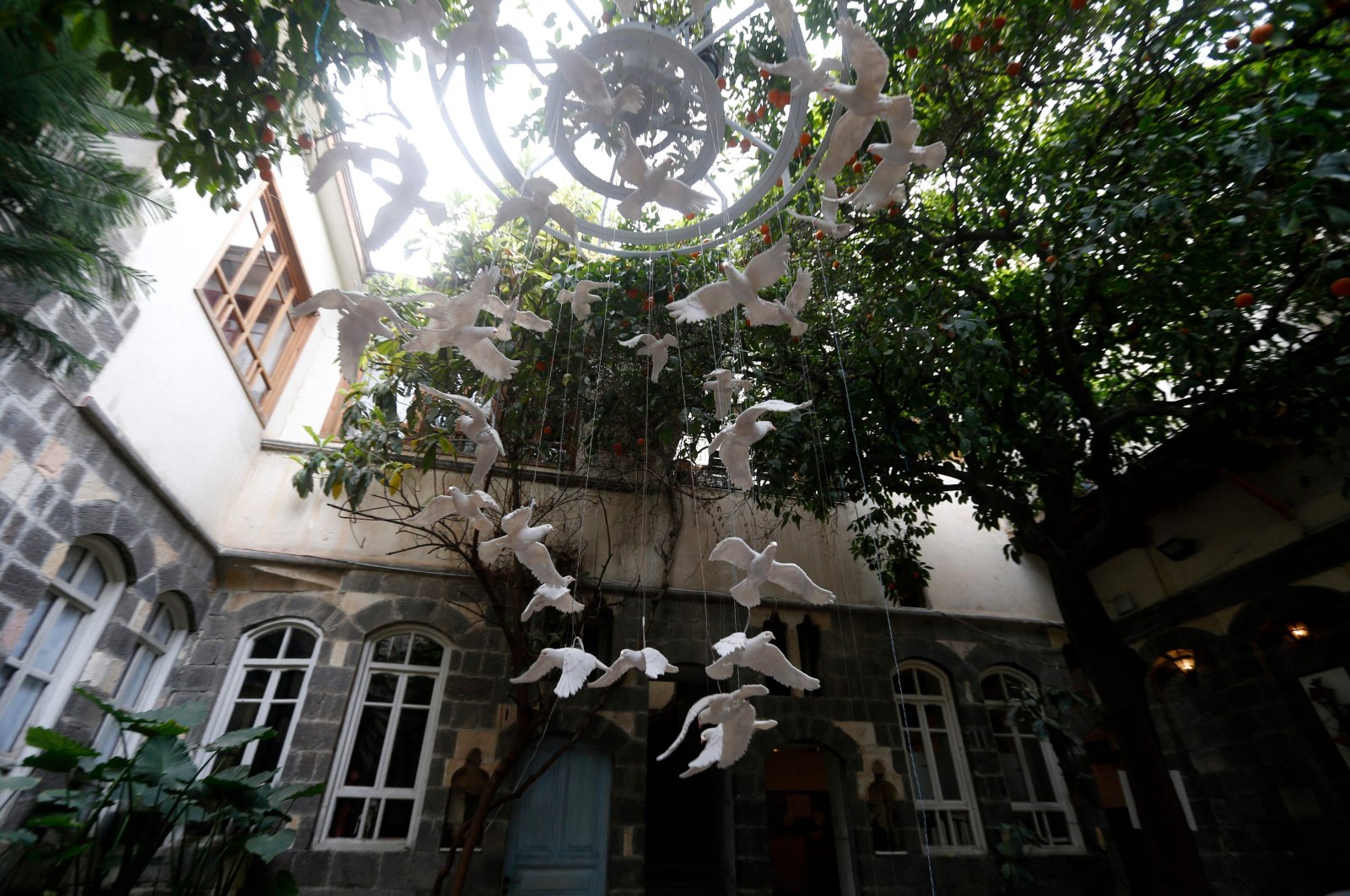 An art installation using ceramic pigeons is pictured inside a courtyard in old Damascus, as part of an exhibition titled &quot;Once Upon a Time... Windows,&quot; in the Syrian capital, on April 8, 2022. (AFP)