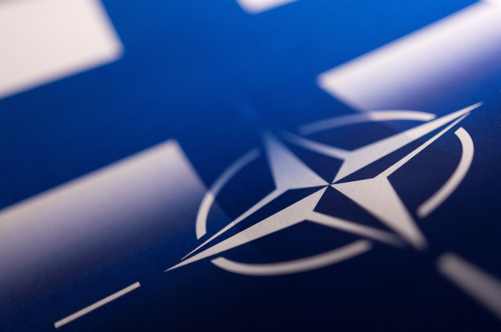 Finnish and NATO flags are seen printed on paper this illustration taken on April 13, 2022. (Reuters Photo)