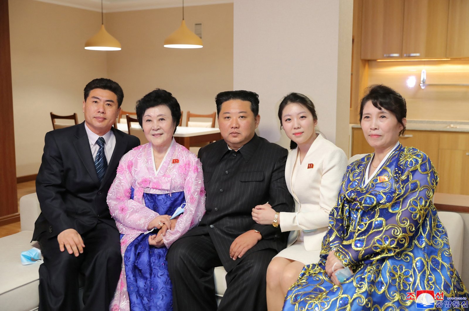 North Korean leader Kim Jong Un poses with North Korean announcer Ri Chun Hi and her family at a house in a terraced residential district on the bank of the Pothong River during the completion ceremony, in Pyongyang, North Korea, April 13, 2022. (Reuters Photo)