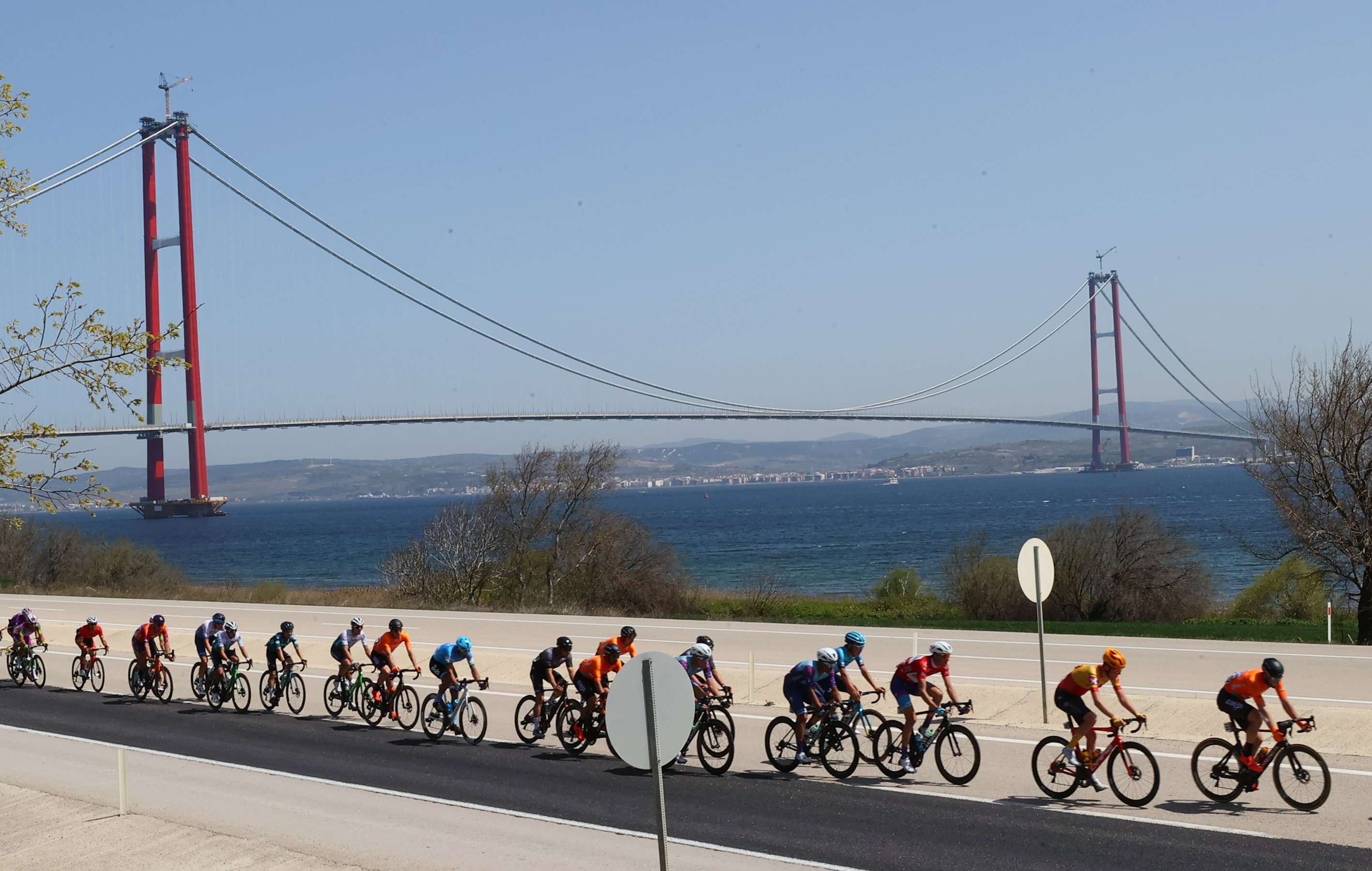Sekelompok pengendara sepeda dilatarbelakangi oleh Jembatan anakkale 1915 selama Tahap 6 dari Tour of Türkiye, anakkale, Turki, 15 April 2022. (AA Photo)