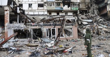 A serviceperson stands at a building damaged during fighting in Mariupol, Ukraine, April 13, 2022. (AP Photo)