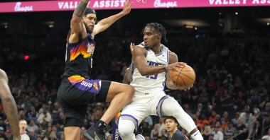 Kings guard Davion Mitchell (R) drives on Suns center JaVale McGee in an NBA game, Phoenix, U.S., April 10, 2022. (AP Photo)