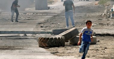 Palestinians are seen amid tear gas fired by Israeli security forces at the main street of Beita village in the occupied West Bank, Palestine, April 15, 2022. (AFP Photo)