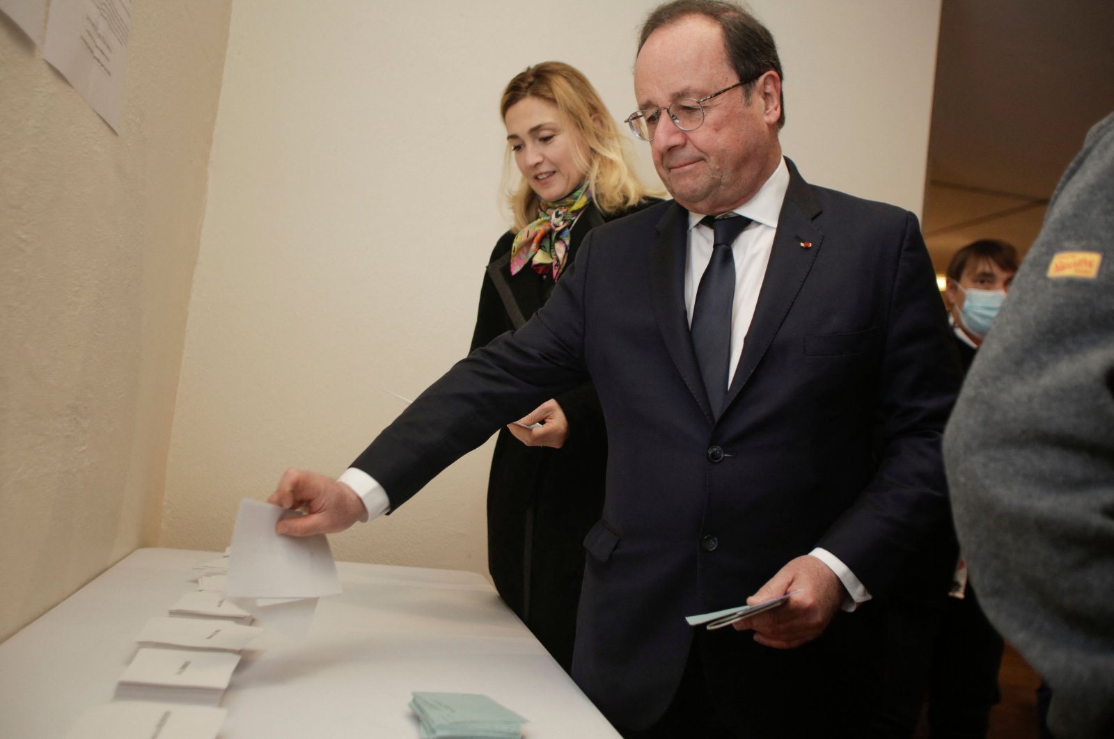 Former French President Francois Hollande (R) and his wife French actress Julie Gayet (L) choose their ballots as they arrive to vote during first round of France&#039;s presidential election at a polling station in Tulle, France, April 10, 2022. (AFP Photo)