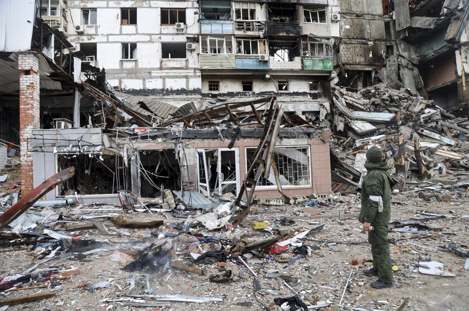A serviceperson stands at a building damaged during fighting in Mariupol, Ukraine, April 13, 2022. (AP Photo)