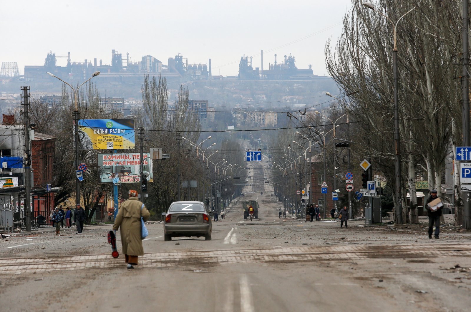 The Ilyich Iron and Steel Works factory is seen in the background of a street damaged during Russia&#039;s siege of the port city of Mariupol, Ukraine, April 14, 2022. (Reuters Photo)