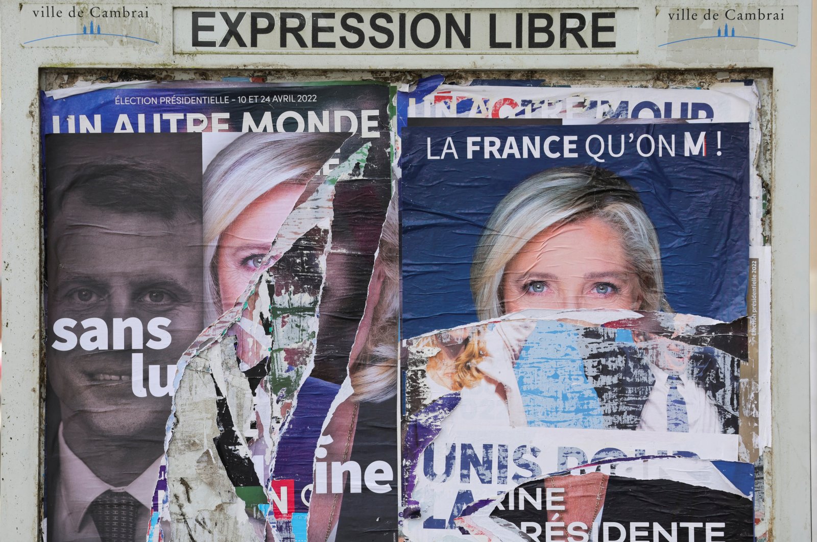 A torn poster in support of Marine Le Pen, leader of the French far-right National Rally (Rassemblement National) party and candidate for the 2022 French presidential election, is pictured on a free billboard in Cambrai, France, April 15, 2022. (Reuters Photo)