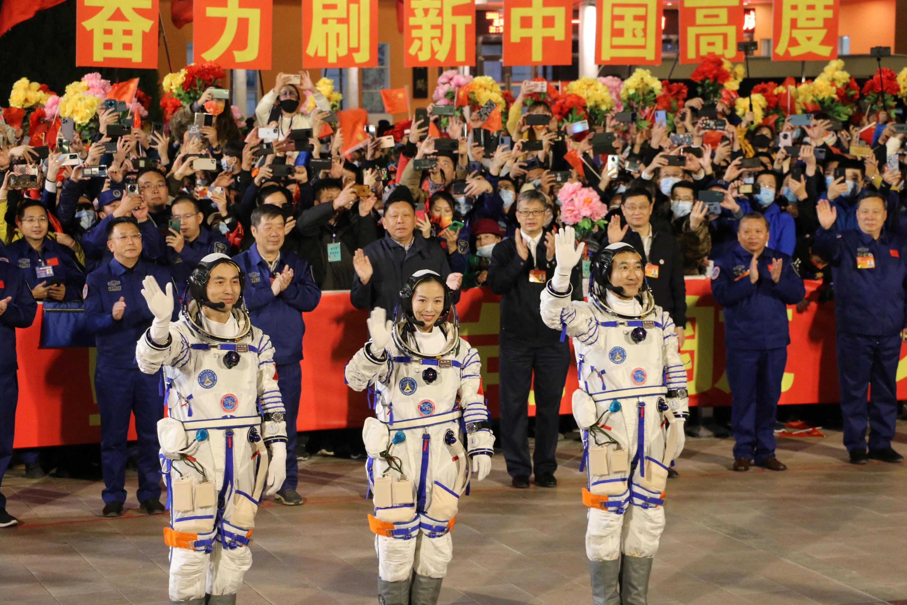Astronot (kiri) Ye Guangfu, Wang Yaping dan Zhai Zhigang, melambai pada upacara keberangkatan sebelum peluncuran mereka di pesawat ruang angkasa Shenzhou 13 di Pusat Peluncuran Satelit Jiuquan di gurun Gobi, di barat laut China, 15 Oktober 2021. (AFP File Foto)