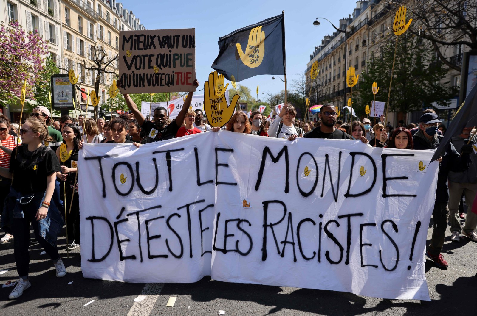 Protestors march behind a banner that translates as &quot;everybody hates racists&quot; during a demonstration against racism and fascism in Paris on April 16, 2022. (AFP Photo)