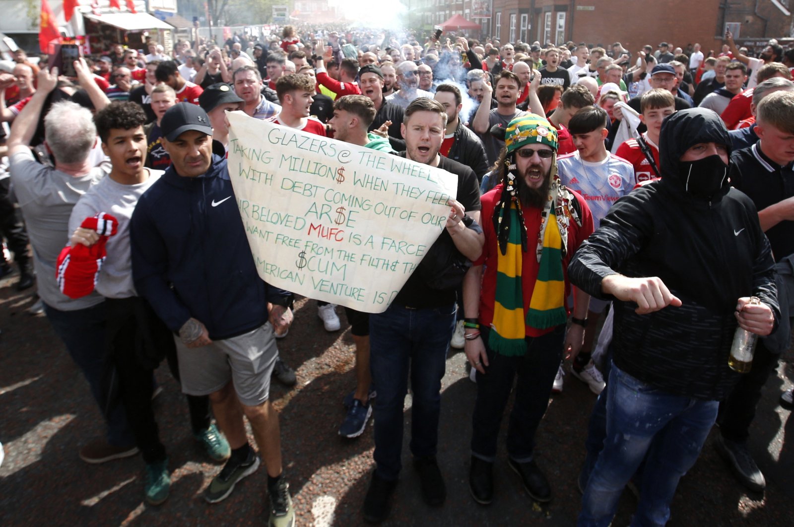 Manchester United fans march while displaying banners in protest of the Glazer family’s ownership of the club outside the stadium before the match, Old Trafford, Manchester, Britain, April 16, 2022.  (Reuters Photo)