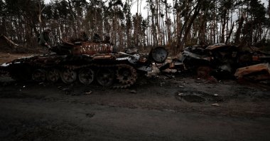 A man stands on the top of a destroyed Russian tank, amid Russia&#039;s invasion of Ukraine near Buzova, Kyiv region, Ukraine, April 10, 2022. (Reuters Photo)