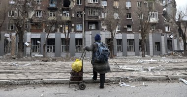 A local resident looks at damage during heavy fighting near the Illich Iron & Steel Works Metallurgical Plant, in an area controlled by Russian-backed separatist forces in Mariupol, Ukraine, April 16, 2022. (AP Photo)