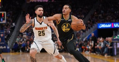 Warriors' Jordan Poole (R) dribbles past Nuggets' Austin Rivers in an NBA playoffs game, San Francisco, California, U.S., April 16, 2022. (Reuters Photo)