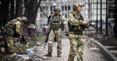 Russian soldiers walk along a street in Mariupol, as Russian troops intensify a campaign to take the strategic port city, part of an anticipated massive onslaught across eastern Ukraine, April 12, 2022. (AFP File Photo)