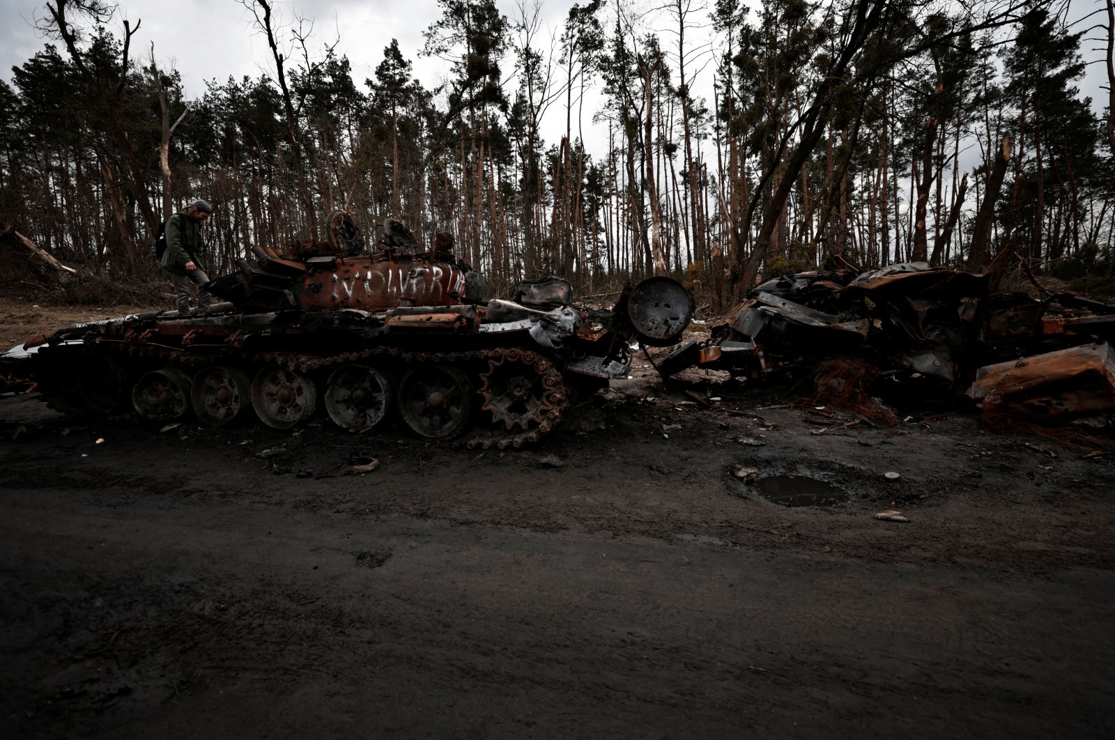 A man stands on the top of a destroyed Russian tank, amid Russia&#039;s invasion of Ukraine near Buzova, Kyiv region, Ukraine, April 10, 2022. (Reuters Photo)