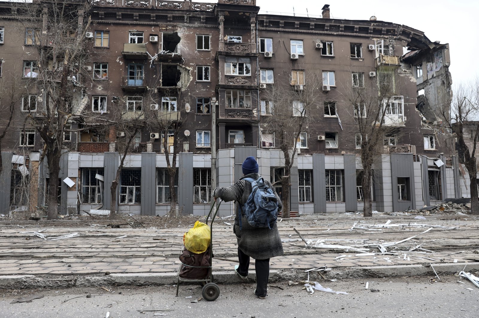 A local resident looks at damage during heavy fighting near the Illich Iron & Steel Works Metallurgical Plant, in an area controlled by Russian-backed separatist forces in Mariupol, Ukraine, April 16, 2022. (AP Photo)