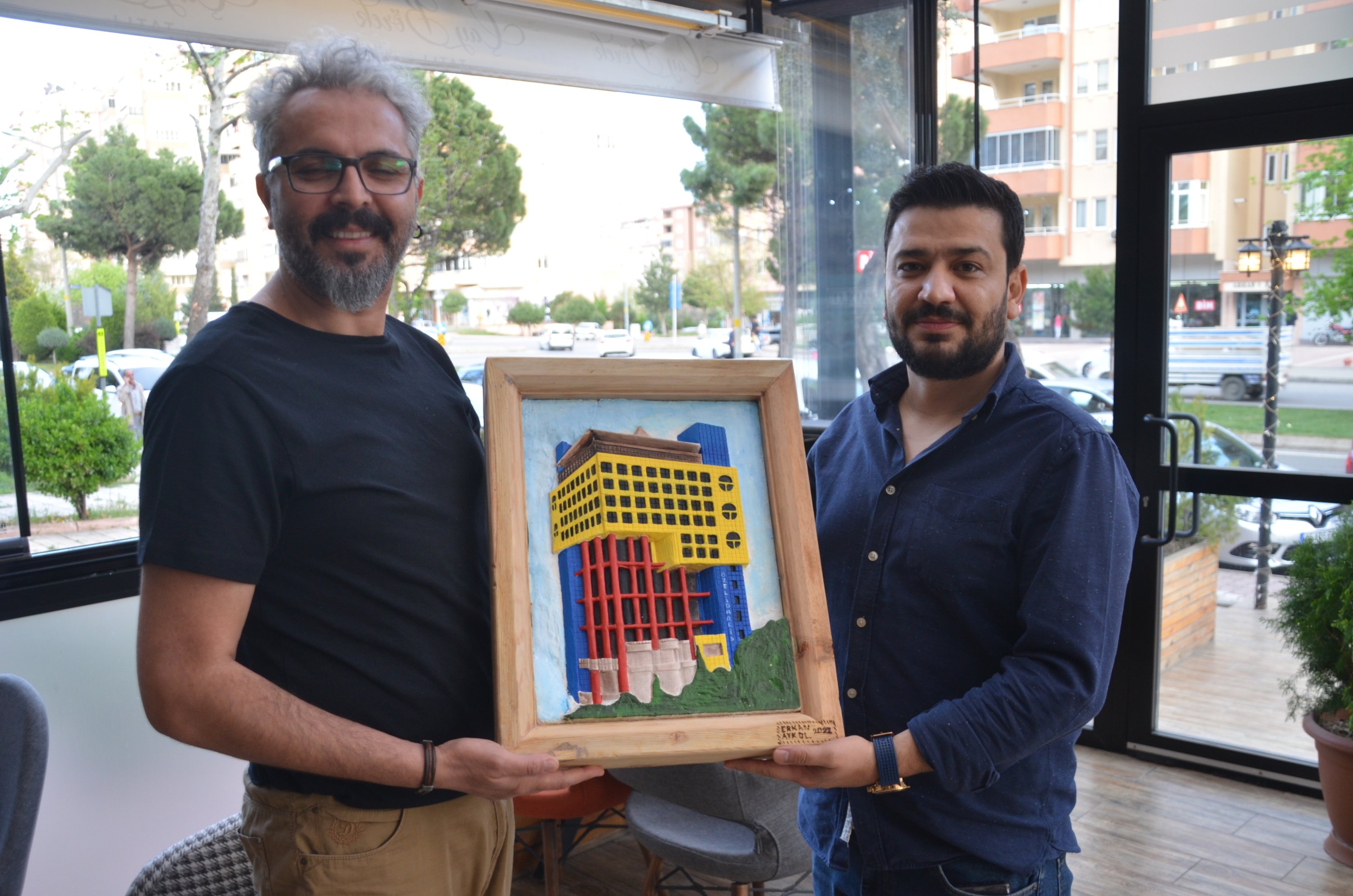 Guru seni Erkan Akyol memberikan potret gedung paling konyol di dunia kepada temannya, Kahramanmaraş, Turki, 18 April 2022. (AA Photo)