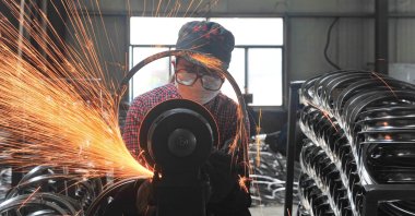 A worker welds wheels at a factory in Hangzhou in China&#039;s eastern Zhejiang province, April 17, 2022. (AFP Photo)